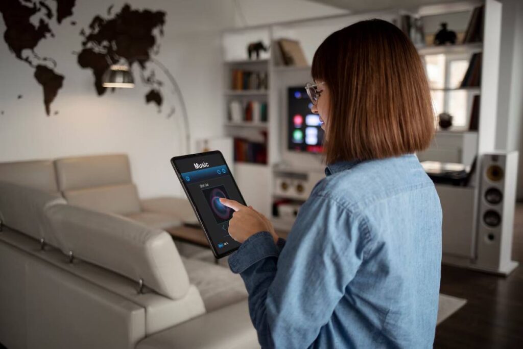 Woman using a smart home device to control music in a modern living room.