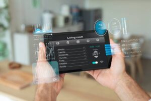 A person holding a transparent digital tablet displaying various environmental and statistical data for a living room.