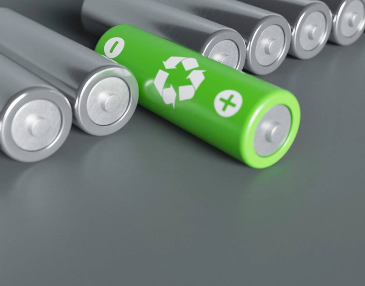 Several cylindrical batteries, including one with a green recycling symbol, prominently displayed among others. 