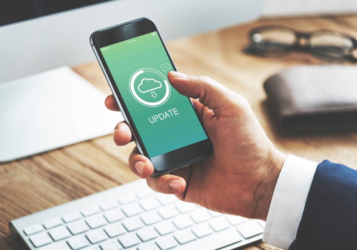 A person in a suit updates a mobile phone app, with an 