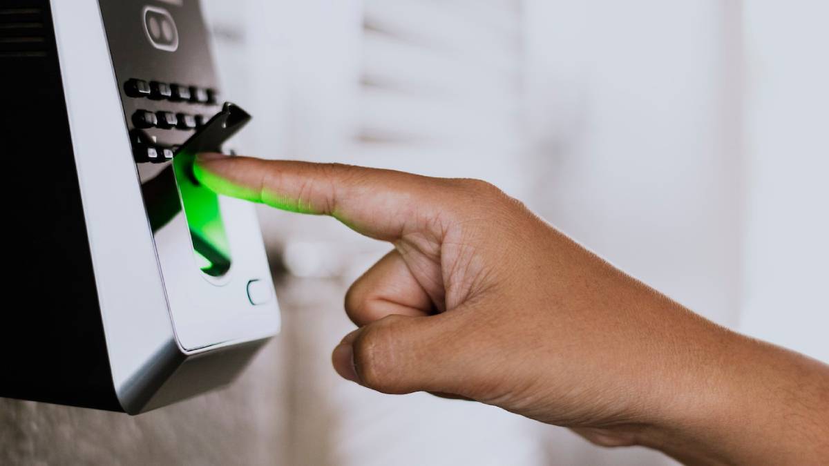  Person using a biometric scanner with a green glowing light to verify identity.